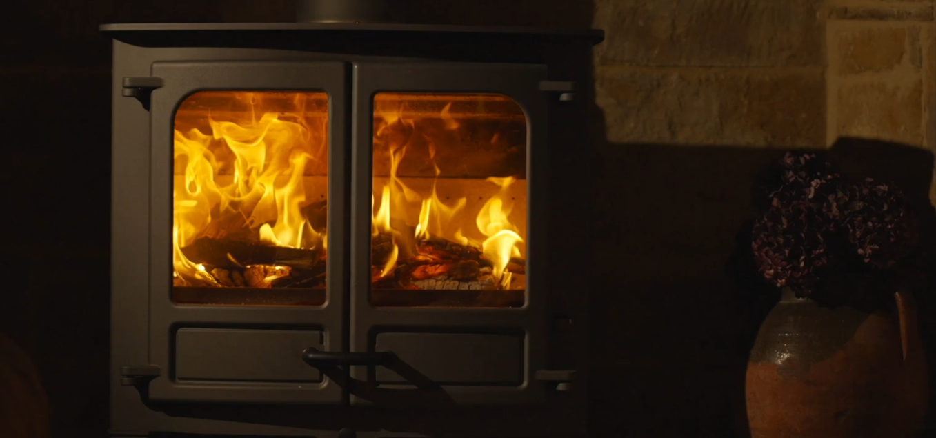 Feu de bois dans une cuisinière à deux portes vitrées